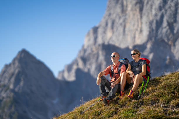 dwie osoby wędrowne, para siedząca na pastwiskach wysokie góry zamazane w tle - mountain freedom european alps austria zdjęcia i obrazy z banku zdjęć