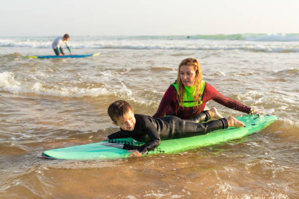 istock Mother helping son surfing on board 1211724930