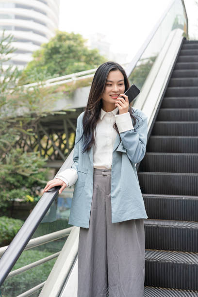 istock A young Asian business woman is using mobile voice messages 1211725755