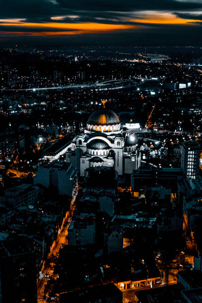 luzes da cidade de belgrado e o iluminado templo de st. sava, tirado de um drone na hora dourada - belgrade churches - fotografias e filmes do acervo