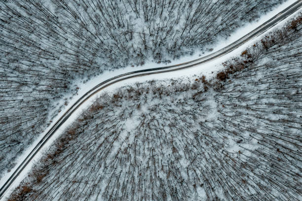 istock A drone view of a road cutting through the snow-covered forest 1211729330