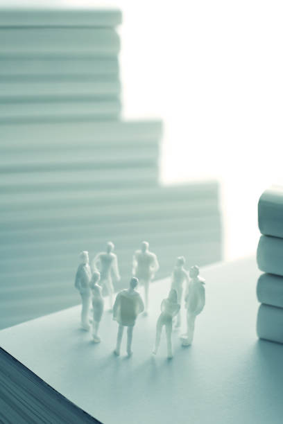 istock Stacked white books and human 1211729597