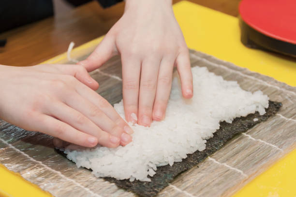 Children prepare sushi rolls. Master-class in the restaurant. Selective focus