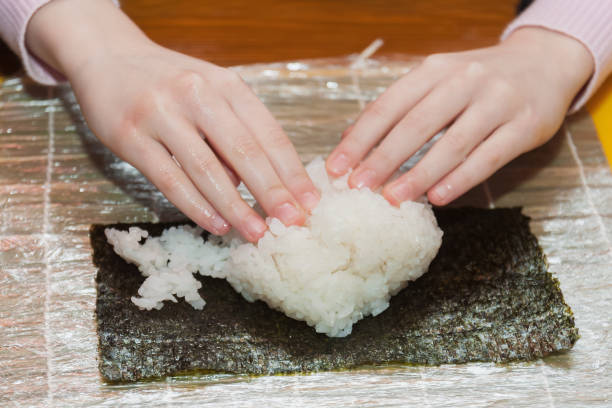 istock Children prepare sushi rolls. Master-class in the restaurant. Selective focus 1211731617