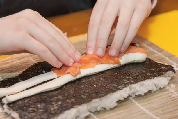 istock Children prepare sushi rolls. Master-class in the restaurant. Selective focus 1211731630