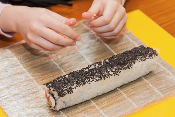 istock Children prepare sushi rolls. Master-class in the restaurant. Selective focus 1211731656