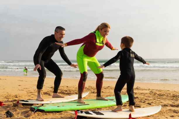 istock Family sanding on surfboards on beach 1211731693