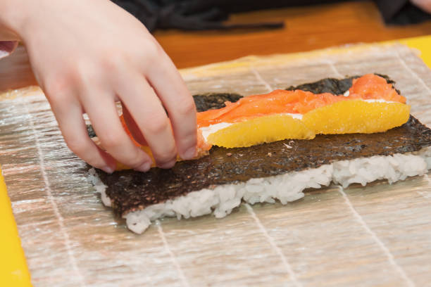 Children prepare sushi rolls. Master-class in the restaurant. Selective focus