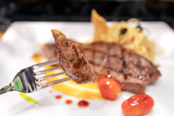 istock Medium grilled striploin beef steak with spaghetti olio a side dish served on white dish. 1211731915