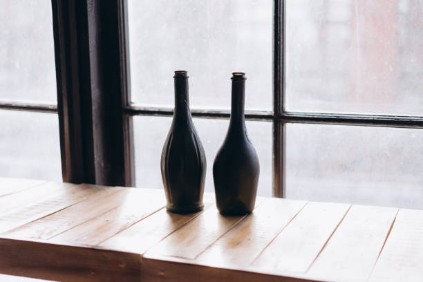 two black vintage bottles on window background