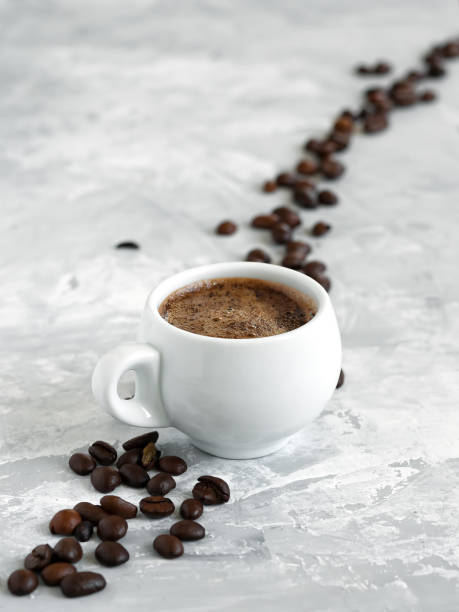 istock Cup with espresso arranged on a gray background. Roasted coffee beans are located around a cup of coffee. 1211734639