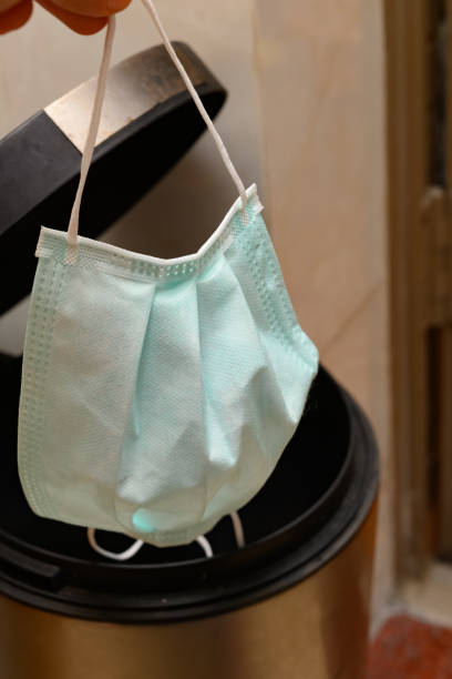 istock throwing an used medical mask to a rubbish bin 1211739480