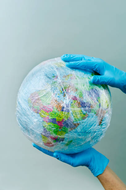 istock doctor with a world globe wrapped in plastic 1211741018