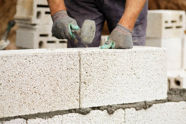 istock Close-up of construction worker builds brick wall 1211746313
