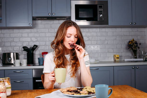 istock Woman eating cookie and drinking milk. 1211746350