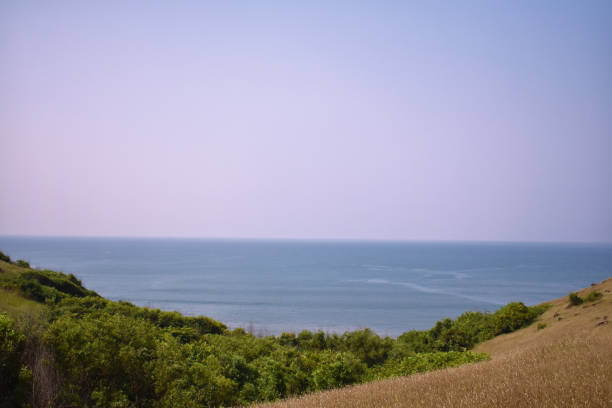 a view of a ocean and the horizon in middle of two mountain a view of a ocean and the horizon in middle of two mountain chapora fort stock pictures, royalty-free photos & images