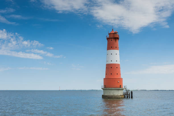 faro de arngast con cielo azul de pie en el agua cerca de wilhelmshaven, baja sajonia, alemania - lighthouse beacon north sea coastal feature fotografías e imágenes de stock