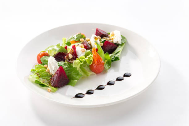 Salad with roasted beetroot, tomato, soft goat cheese isolated on white background side view