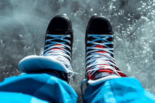 istock Subjective view downwards on legs with ice skates standing on ice 1211754978