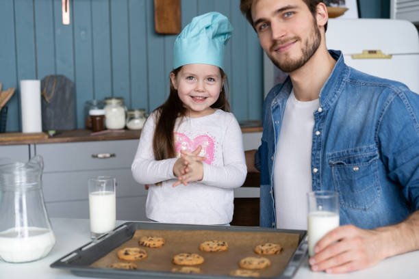 istock father and daughter making cookies in kitchen 1211756537