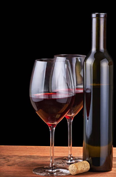 istock two glasses and bottle with red wine isolated on black 1211756756