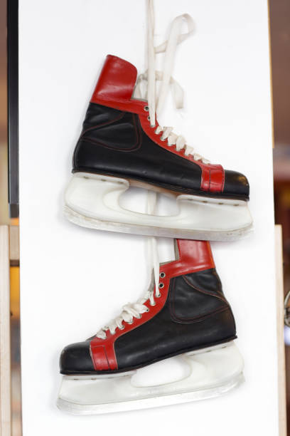 istock winter ice skating boots hang on hook on white wall background 1211760544