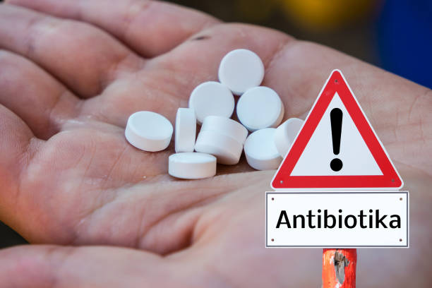 istock Antibiotics hand warning sign with tablets in german 1211762513