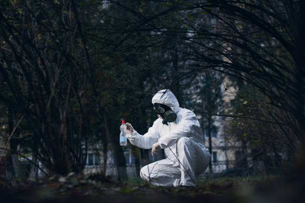 istock Scientist doing research outdoors, wearing white coverall and gas mask 1211762659