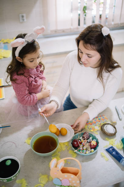 istock Mom take out egg from bowl with yellow paint 1211765048