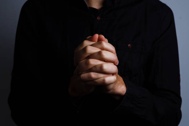 istock Image of praying hands on a black background 1211765159