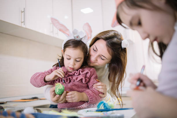 istock Happy family preparing eggs for Easter holiday 1211765445