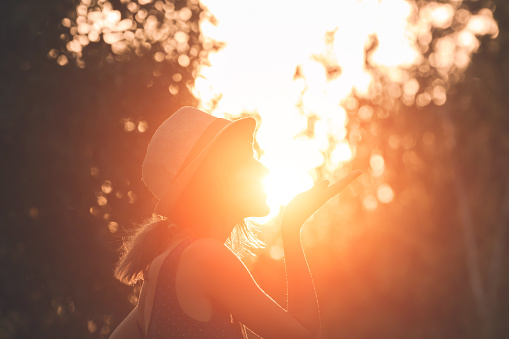 Mujer soplando beso y sosteniendo el sol en perspectiva forzada. photo
