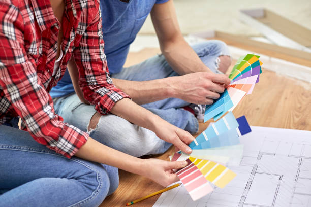 istock smiling couple looking at color samples at home 1211767032