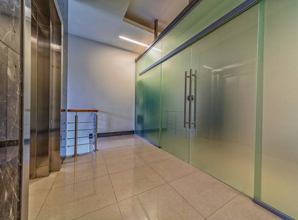 Modern frosted glass doors entrance near elevator Modern frosted glass doors entrance near elevator in corporate office building frosted glass door office stock pictures, royalty-free photos & images