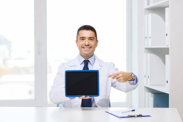 istock smiling male doctor showing tablet pc blank screen 1211768452