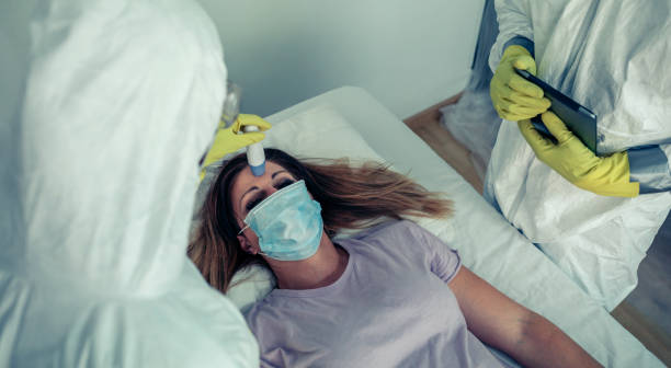 istock Patient attended by doctors who check if she has fever 1211768654