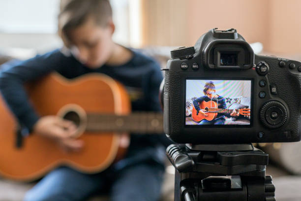 menino tocando guitarra na câmera - video sharing - fotografias e filmes do acervo