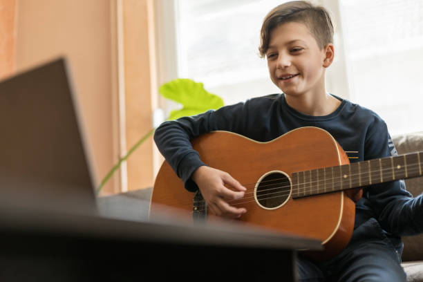Kid having online guitar lesson and smiling
