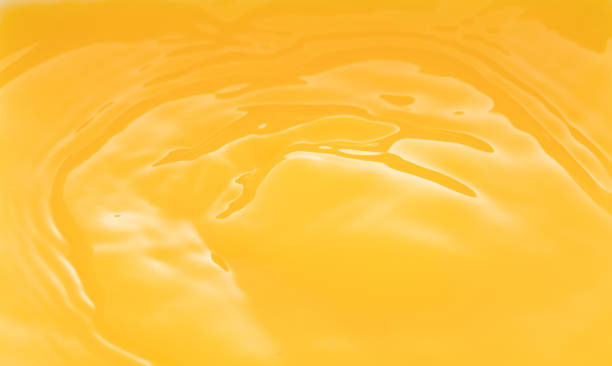 istock a swirling wave on the surface of orange juice. 1211771167