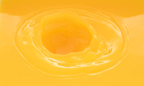 istock a swirling wave on the surface of orange juice. 1211771226