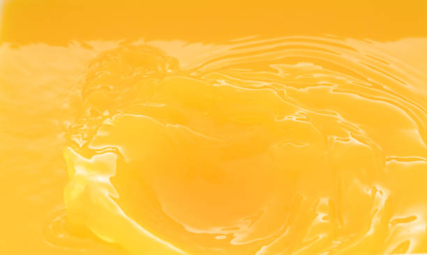 istock a swirling wave on the surface of orange juice. 1211771229