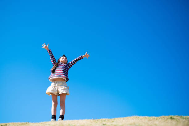 istock Girl with open arms on meadow 1211774016