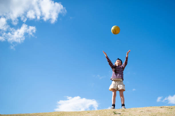 istock Child playing with a ball on the lawn 1211774032