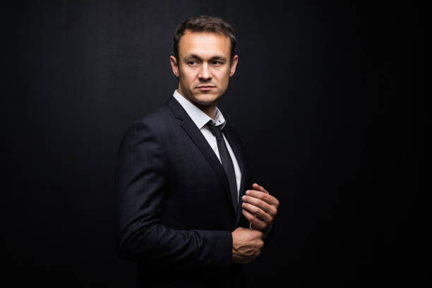 istock Young handsome businessman on a black background 1211774387