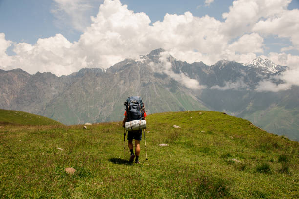 istock Hiker with backpack walks among hills and mountains 1211775829