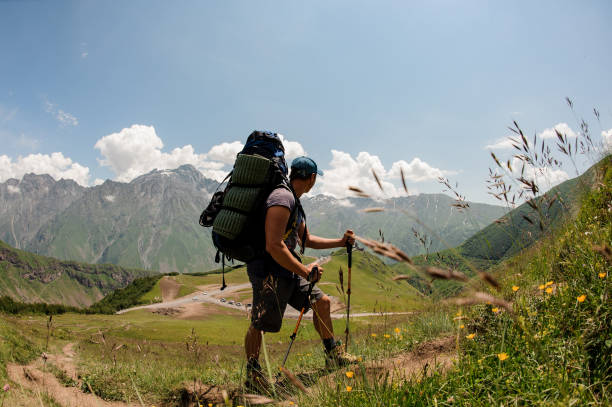 istock Hiker with backpack travels among hills and mountains 1211776336