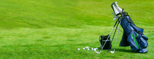 Bag of golf clubs on the golf course banner format stock photo