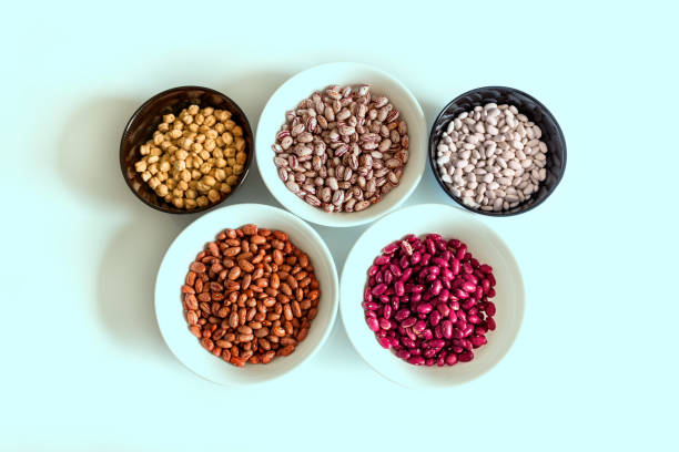 Phaseolus. Bright multi-colored beans, mung beans and chickpeas in ceramic cups.