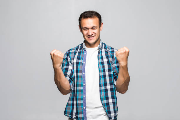 istock Young handsome man celebrating a victory on a white background 1211784777