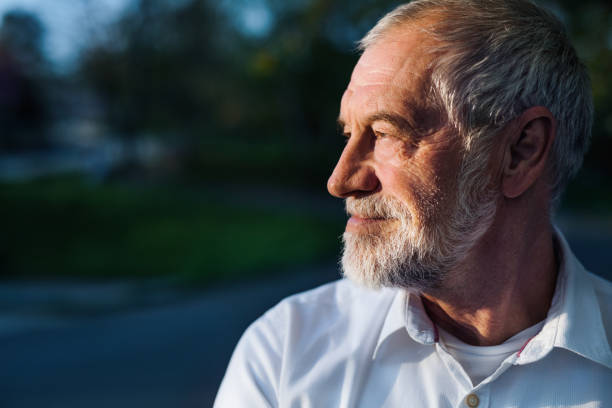istock Senior man standing outside in spring nature. Copy space. 1211785107